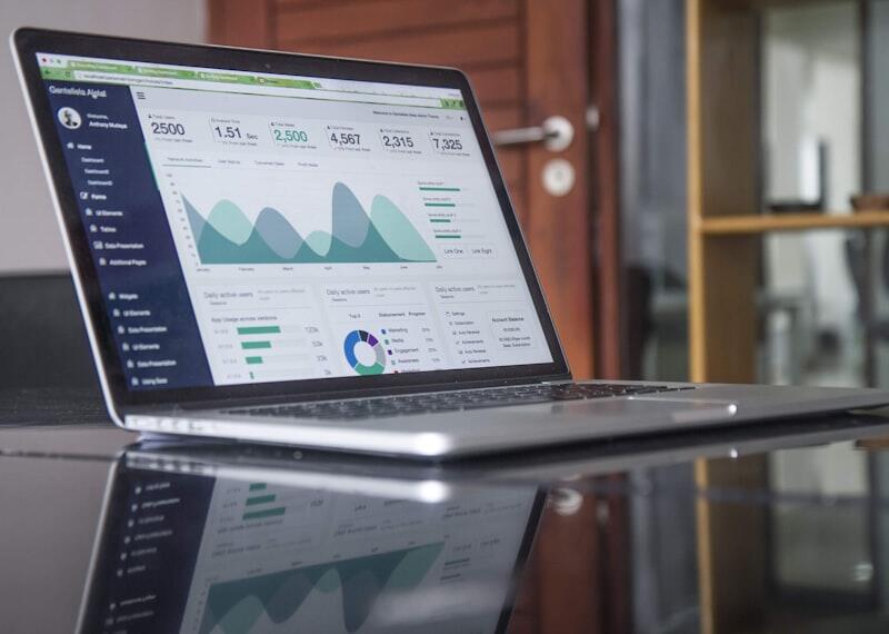 Business analytics dashboard on laptop showing growth metrics and traffic data